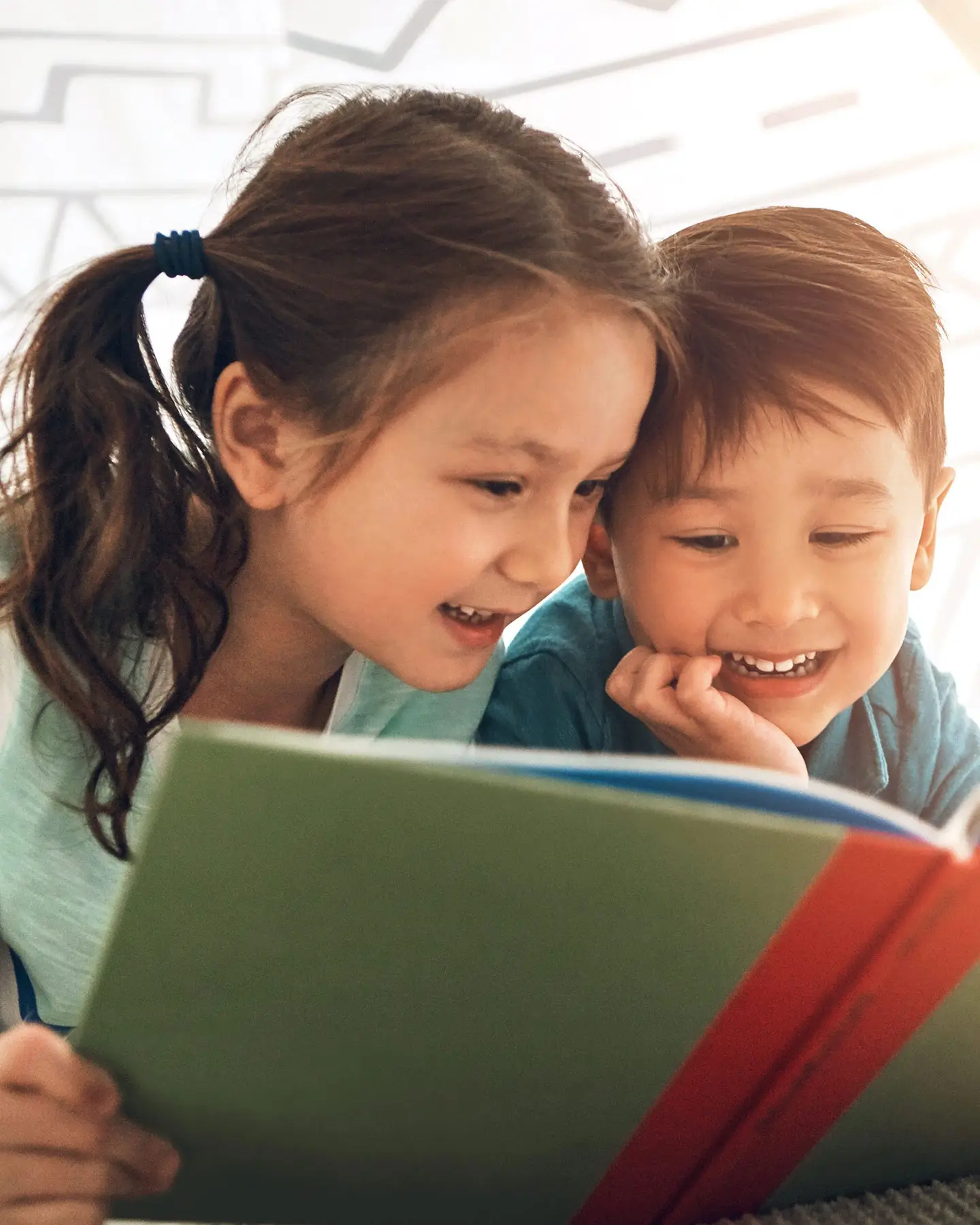 a young boy and girl reading a book
