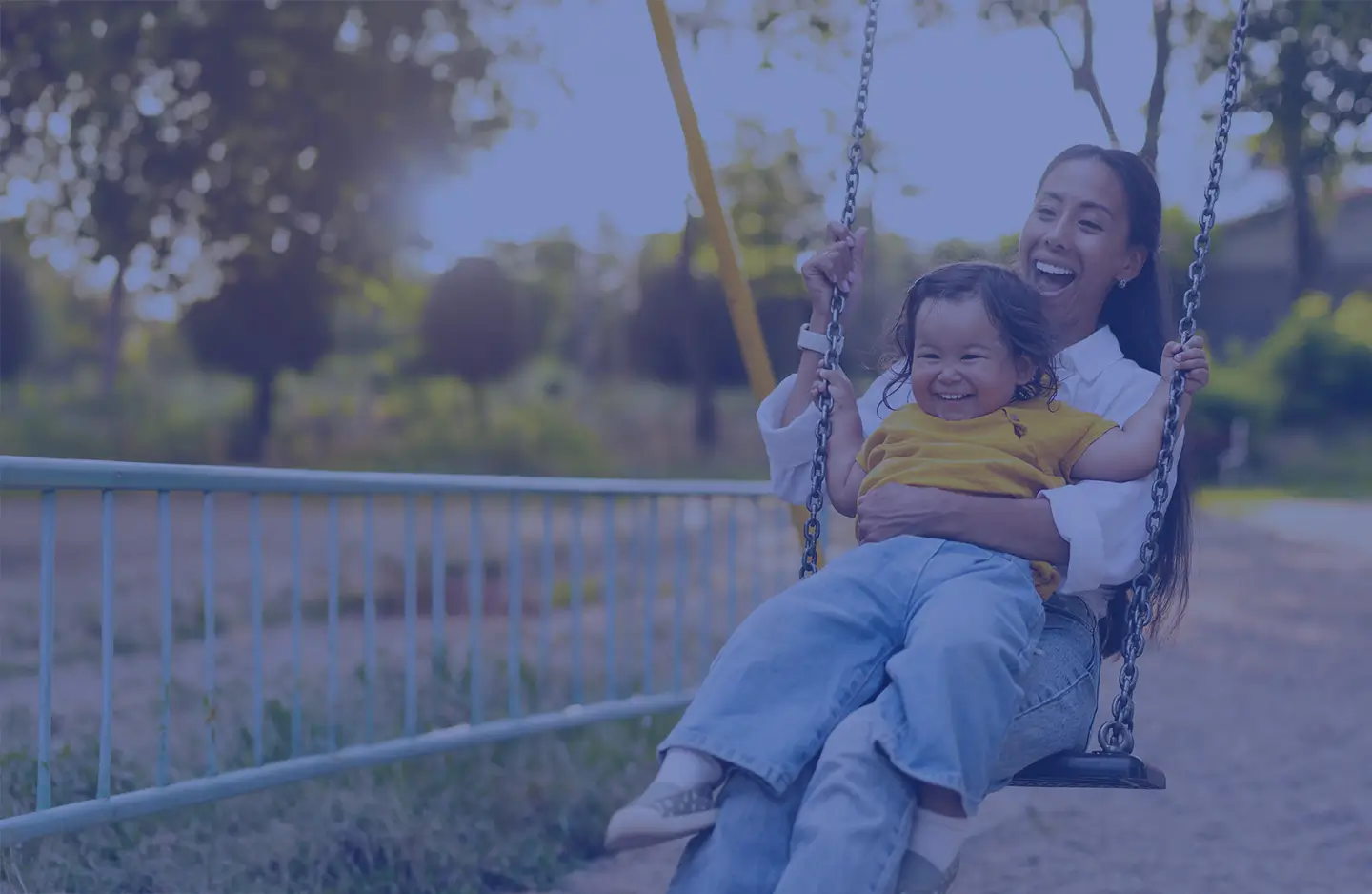 happy mom and small child laughing on swing